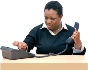 Photograph of someone dialing a number on a telephone