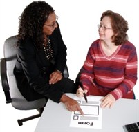 Photo of a staff member helping someone fill out a referral form