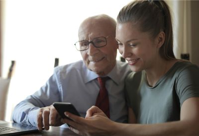 Younger woman and older man looking at a phone together.jpg